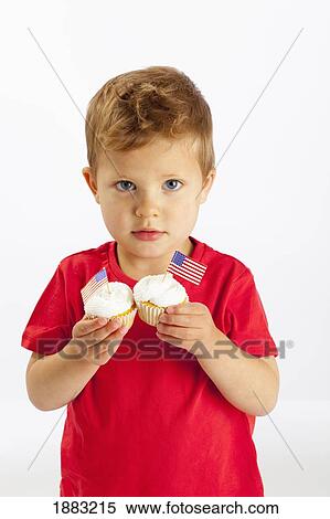 A Young Boy Holds Two Cupcakes With American Flags In Them View Large Photo Image Stock Photography - A Young Boy Holds Two Cupcakes With American Flags In Them. Fotosearch