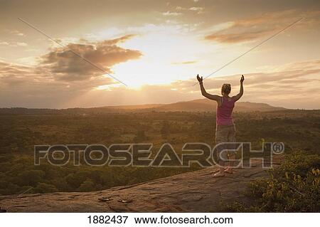 A Young Woman Looking Over The African Landscape With Arms Raised; Manica, Mozambique, Africa View Large Photo Image Stock Photo - A Young Woman Looking Over The African Landscape With Arms Raised; Manica, Mozambique, Africa. Fotosearch
