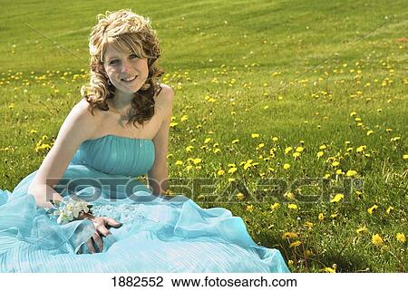 A Young Woman Wearing A Formal Dress And Sitting On The Grass; Camrose, Alberta, Canada View Large Photo Image Stock Image - A Young Woman Wearing A Formal Dress And Sitting On The Grass; Camrose, Alberta, Canada. Fotosearch