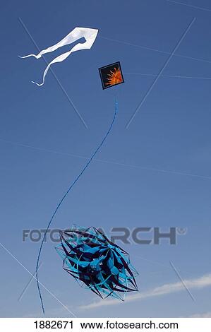 Stock Image - Decorative Kites Flying In A Blue Sky; Port Colborne, Ontario, Canada. Fotosearch