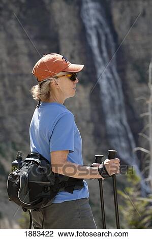 Female Hiker With A Waterfall In The Background; Waterton, Alberta, Canada View Large Photo Image Stock Image - Female Hiker With A Waterfall In The Background; Waterton, Alberta, Canada. Fotosearch