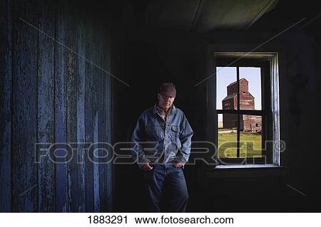 Portrait Of A Farmer/Rancher In An Old Abandoned Ghost Town Store With A Grain Elevator Seen Out The Window; Bents, Saskatchewan, Canada View Large Photo Image Stock Image - Portrait Of A Farmer/Rancher In An Old Abandoned Ghost Town Store With A Grain Elevator Seen Out The Window; Bents, Saskatchewan, Canada. Fotosearch