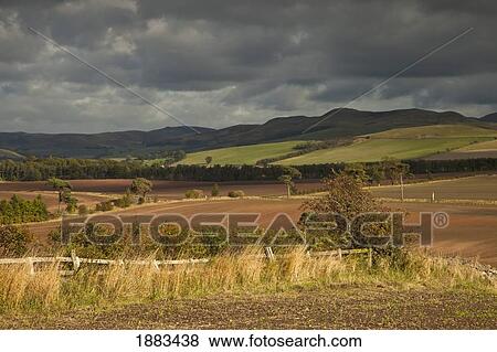 Rolling Hills And Mountains Under A Cloudy Sky; Cessford, Scottish Borders, Scotland View Large Photo Image Stock Photo - Rolling Hills And Mountains Under A Cloudy Sky; Cessford, Scottish Borders, Scotland. Fotosearch