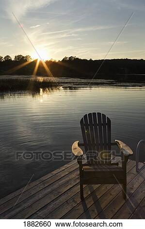 Sunset On A Lake With A Dock And Wooden Arm Chair; Flesherton, Ontario, Canada View Large Photo Image Stock Image - Sunset On A Lake With A Dock And Wooden Arm Chair; Flesherton, Ontario, Canada. Fotosearch