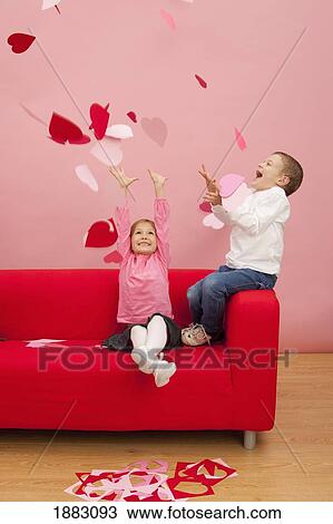 Stock Image - Two Children Throwing Hearts Into The Air. Fotosearch