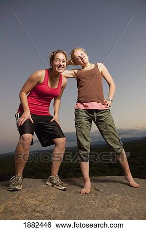 Two Young Women Doing Silly Poses On A Rock; Manica, Mozambique, Africa View Large Photo Image Stock Photograph - Two Young Women Doing Silly Poses On A Rock; Manica, Mozambique, Africa. Fotosearch