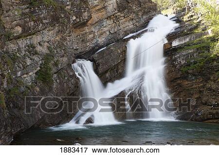 Stock Photo - Waterfalls Coming Out Of A Rock Cliff; Waterton, Alberta, Canada. Fotosearch
