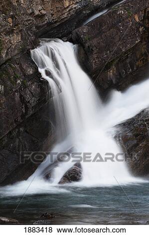 Stock Photo - Waterfalls Coming Out Of A Rock Cliff; Waterton, Alberta, Canada. Fotosearch