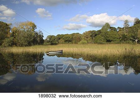 Stock Image - a boat in the water in killarney national park in munster region; county kerry, ireland. Fotosearch