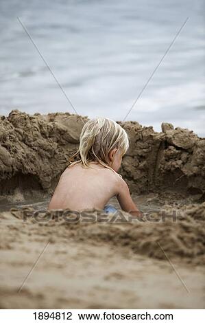 a boy plays in the sand by the water; currumbin, gold coast, queensland, australia View Large Photo Image Stock Image - a boy plays in the sand by the water; currumbin, gold coast, queensland, australia. Fotosearch