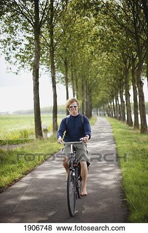 Stock Photo - a boy riding his bike along the dutch canals; houten, the netherlands. Fotosearch