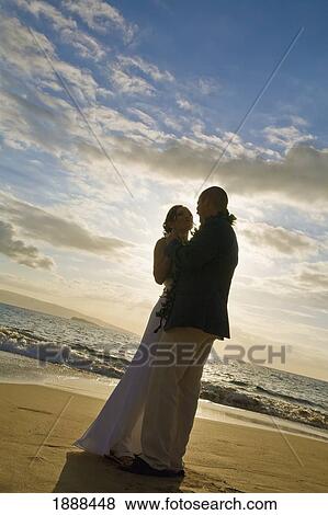 Stock Photo - a bride and groom on a beach; maui, hawaii, united states of america. Fotosearch