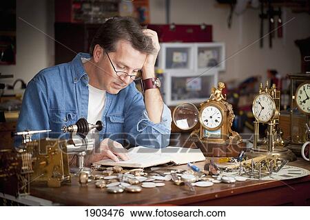 a clock maker and repairman reading his bible in his shop; st. catharines, ontario, canada View Large Photo Image Stock Photograph - a clock maker and repairman reading his bible in his shop; st. catharines, ontario, canada. Fotosearch
