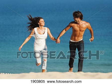 a couple running and holding hands on punta paloma beach; tarifa, cadiz, andalusia, spain View Large Photo Image Stock Photography - a couple running and holding hands on punta paloma beach; tarifa, cadiz, andalusia, spain. Fotosearch