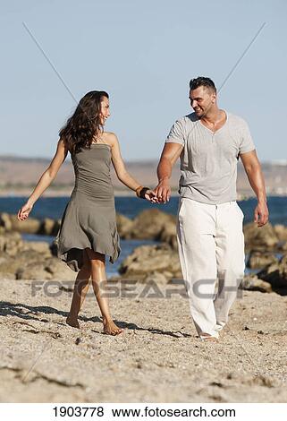 a couple walks holding hands on bunker beach; tarifa, cadiz, andalusia, spain View Large Photo Image Stock Photo - a couple walks holding hands on bunker beach; tarifa, cadiz, andalusia, spain. Fotosearch