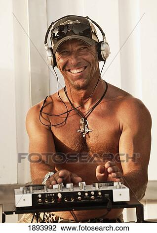 Stock Image - a disc jockey playing music at explora beach bar; tarifa, cadiz, andalusia, spain. Fotosearch