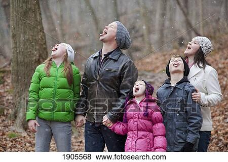 Stock Photo - a family catching snowflakes on their tongues; grimsby, ontario, canada. Fotosearch