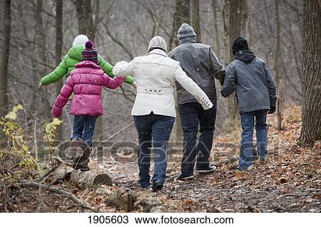 a family taking a walk in the forest in autumn during a snowfall; grimsby, ontario, canada View Large Photo Image Stock Image - a family taking a walk in the forest in autumn during a snowfall; grimsby, ontario, canada. Fotosearch