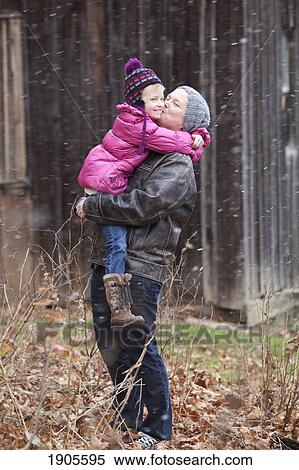 a father holding his daughter and kissing her on the cheek; grimsby, ontario, canada View Large Photo Image Stock Photography - a father holding his daughter and kissing her on the cheek; grimsby, ontario, canada. Fotosearch