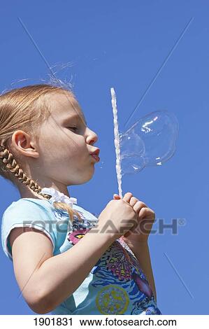 a girl blowing bubbles against a blue sky; portland, oregon, united states of america View Large Photo Image Stock Image - a girl blowing bubbles against a blue sky; portland, oregon, united states of america. Fotosearch