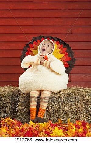 a girl in a turkey costume sitting on a hay bale and singing; three hills, alberta, canada View Large Photo Image Stock Photograph - a girl in a turkey costume sitting on a hay bale and singing; three hills, alberta, canada. Fotosearch
