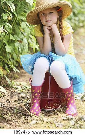 a girl wearing a straw hat and sitting on a large, red pail; troutdale, oregon, united states of america View Large Photo Image Stock Photography - a girl wearing a straw hat and sitting on a large, red pail; troutdale, oregon, united states of america. Fotosearch