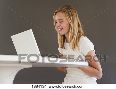 a girl wearing white and using a white laptop computer; benalamadena costa, malaga, andalusia, spain View Large Photo Image Picture - a girl wearing white and using a white laptop computer; benalamadena costa, malaga, andalusia, spain. Fotosearch