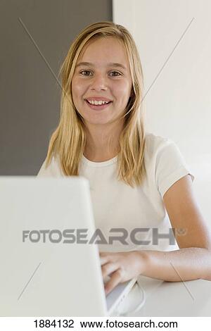 Stock Image - a girl wearing white and using a white laptop computer; benalamadena costa, malaga, andalusia, spain. Fotosearch