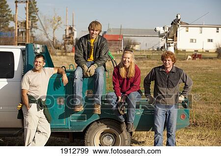 a group of people sitting on the back of a truck; three hills, alberta, canada View Large Photo Image Stock Photo - a group of people sitting on the back of a truck; three hills, alberta, canada. Fotosearch
