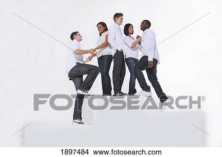 Picture - a group of young adults wearing white hanging out together on white steps; portland, oregon, united states of america. Fotosearch