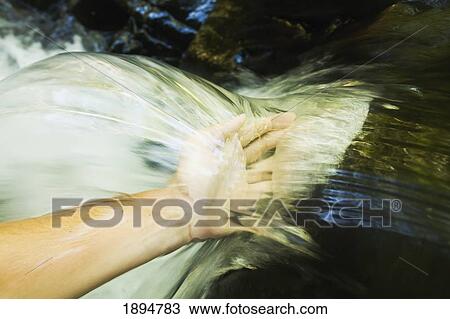 a hand touches the cascade of water at currumbin rock pools in currumbin valley; gold coast, queensland, australia View Large Photo Image Stock Image - a hand touches the cascade of water at currumbin rock pools in currumbin valley; gold coast, queensland, australia. Fotosearch