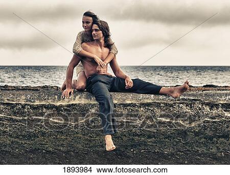 a man and woman sitting on a ledge along the ocean in parque natural del estrecho; tarifa, cadiz, andalusia, spain View Large Photo Image Picture - a man and woman sitting on a ledge along the ocean in parque natural del estrecho; tarifa, cadiz, andalusia, spain. Fotosearch
