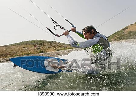 Stock Image - a man kite surfing off the coast of parque natural del estrecho; tarifa, cadiz, andalusia, spain. Fotosearch