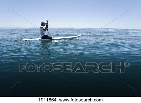 a man paddling on a surfboard; tarifa, cadiz, andalusia, spain View Large Photo Image Picture - a man paddling on a surfboard; tarifa, cadiz, andalusia, spain. Fotosearch
