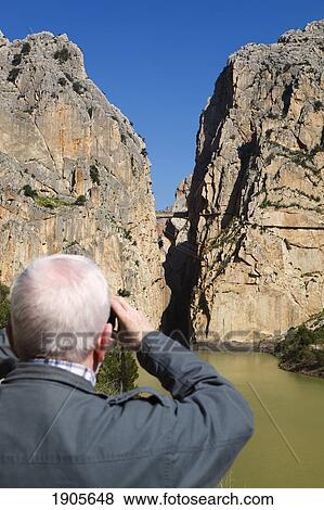Stock Photo - a man photographs el chorro gorge near alora; malaga, spain. Fotosearch