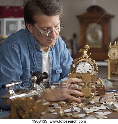 Stock Image - a man repairing clocks; st. catharines, ontario, canada. Fotosearch