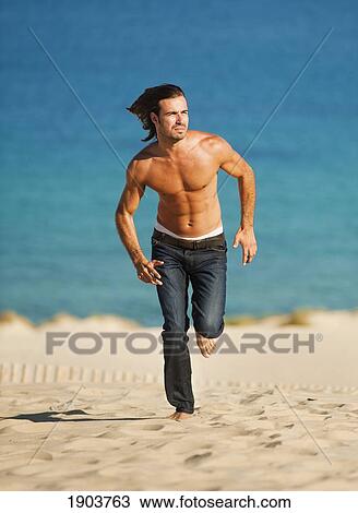 Stock Image - a man running on punta paloma beach; tarifa cadiz, andalusia, spain. Fotosearch