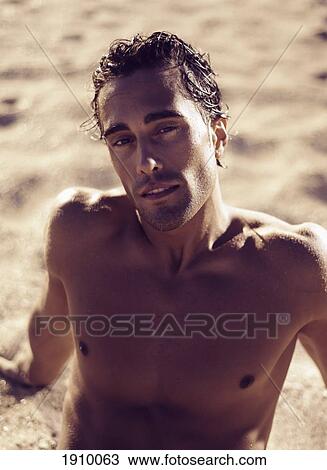 Stock Image - a man sitting on the sand; tarifa, cadiz, andalusia, spain. Fotosearch
