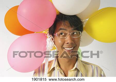 a man with colorful balloons over his head View Large Photo Image Stock Photography - a man with colorful balloons over his head. Fotosearch