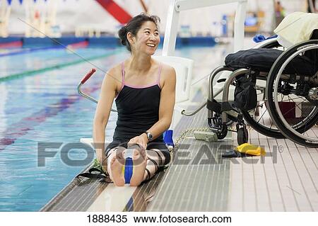 a paraplegic woman sits at the edge of a swimming pool on a lift beside her wheelchair and prepares to swim; edmonton, alberta, canada View Large Photo Image Stock Photography - a paraplegic woman sits at the edge of a swimming pool on a lift beside her wheelchair and prepares to swim; edmonton, alberta, canada. Fotosearch