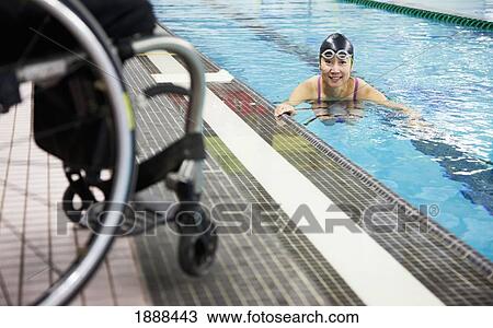 a paraplegic woman swims in a pool with her wheelchair at the water's edge; edmonton, alberta, canada View Large Photo Image Stock Image - a paraplegic woman swims in a pool with her wheelchair at the water's edge; edmonton, alberta, canada. Fotosearch