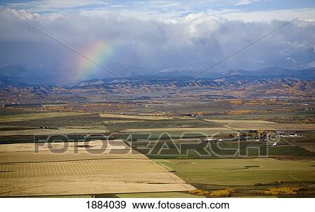 a rainbow over the mountains with storm clouds and the colors of autumn in fields; alberta, canada View Large Photo Image Stock Photo - a rainbow over the mountains with storm clouds and the colors of autumn in fields; alberta, canada. Fotosearch