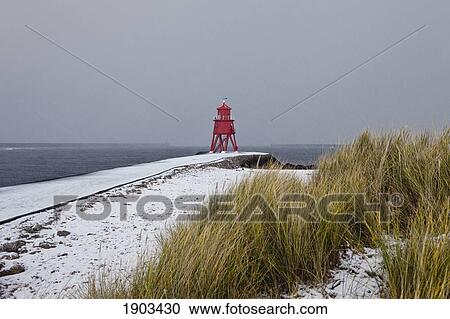 a red lighthouse along the coast under a cloudy sky in winter; south shields, tyne and wear, england View Large Photo Image Stock Image - a red lighthouse along the coast under a cloudy sky in winter; south shields, tyne and wear, england. Fotosearch