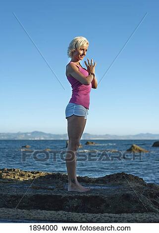Stock Image - a woman doing a yoga pose in parque natural del estrecho; tarifa, cadiz, andalusia, spain. Fotosearch