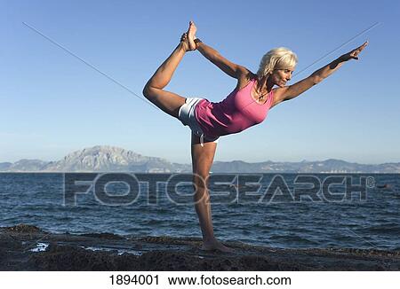 Stock Image - a woman doing a yoga pose in parque natural del estrecho; tarifa, cadiz, andalusia, spain. Fotosearch