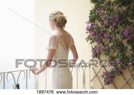 a woman in a white dress looking out over a balcony; london, england View Large Photo Image Stock Photograph - a woman in a white dress looking out over a balcony; london, england. Fotosearch