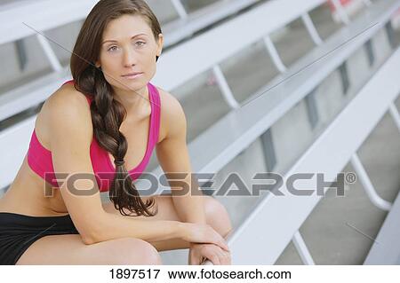 Stock Photo - a woman in workout wear taking a seat on the stands; troutdale, oregon, united states of america. Fotosearch