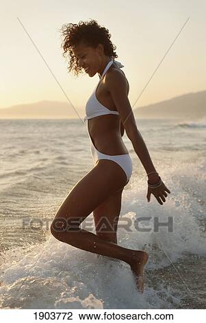 a woman wearing a bathing suit playing in the ocean on los lances beach; tarifa, cadiz, andalusia, spain View Large Photo Image Stock Image - a woman wearing a bathing suit playing in the ocean on los lances beach; tarifa, cadiz, andalusia, spain. Fotosearch