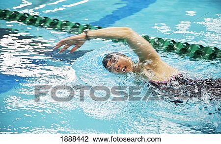 a woman wearing a cap and goggles swims the front stroke in a lane at a swimming pool; edmonton, alberta, canada View Large Photo Image Stock Image - a woman wearing a cap and goggles swims the front stroke in a lane at a swimming pool; edmonton, alberta, canada. Fotosearch
