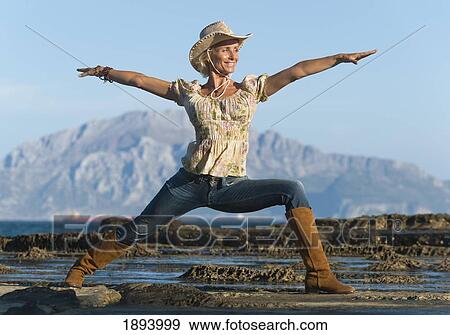 a woman wearing a cowboy hat doing a yoga pose in parque natural del estrecho; tarifa, cadiz, andalusia, spain View Large Photo Image Stock Photo - a woman wearing a cowboy hat doing a yoga pose in parque natural del estrecho; tarifa, cadiz, andalusia, spain. Fotosearch